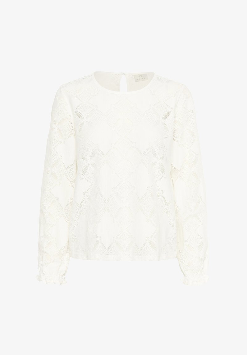 Blouse blanche à manches longues présentant des motifs en dentelle intricats et un col rond, avec des poignets froncés et une ouverture en forme de clé au dos.