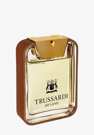 Bottiglia di vetro rettangolare con liquido ambrato chiaro, tappo dorato e etichetta "Trussardi My Land" con emblema sul davanti.