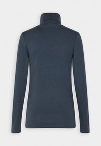 Marinblå långärmad tröja med hög krage, tillverkad av mjukt, texturerat tyg. Har en åtsittande design och sömlösa axlar.