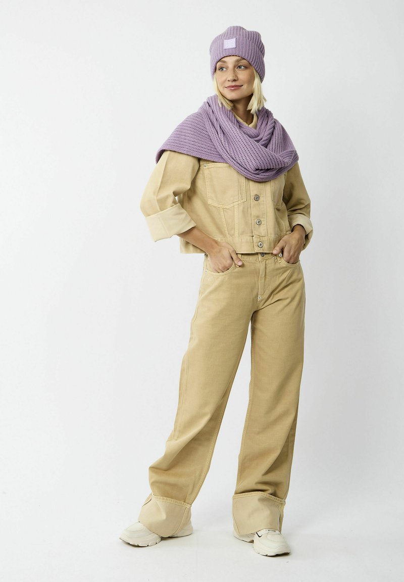 Beige denim jacket met knopen en opgerolde mouwen, bijpassende beige wijde broek, paarse gebreide sjaal en paarse beanie, allemaal met textuur.