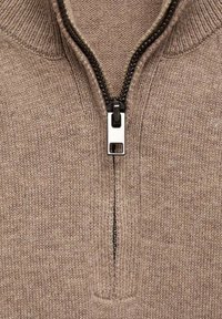 Brun stickad tröja med halvdragkedja, med en metallblixtlås och ribbad krage. Mjuk textur med ett subtilt melerat mönster.