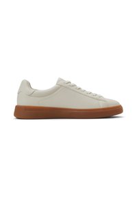 Zapatillas de piel blanca con un perfil bajo, que cuentan con una suela de goma color tan y seis ojales para los cordones, textura suave y un diseño minimalista.