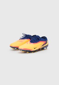 Nike football cleats in bright yellow and navy, featuring a textured upper, black logo, and multi-color studs for traction.