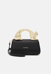 Black leather handbag featuring a gold cat-shaped handle and adjustable strap, with a magnetic closure and subtle logo detail.