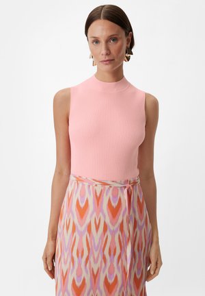 Ärmelloses pinkfarbenes Rippenoberteil mit hohem Ausschnitt, kombiniert mit einem gemusterten Rock in den Farben Orange, Pink und Lavendel sowie einem gebundenen Taillenbund.
