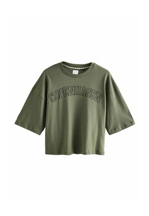 Olivengrünes Baumwoll-T-Shirt mit Rundhalsausschnitt, kurzen weiten Ärmeln und "KOPENHAGEN" in dunklen Buchstaben auf der Vorderseite bedruckt.