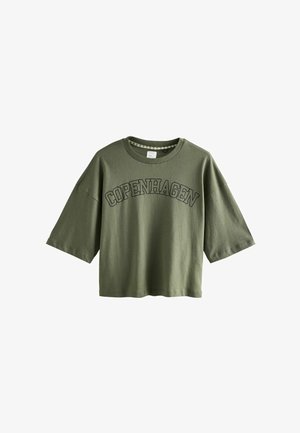 Olivengrünes Baumwoll-T-Shirt mit Rundhalsausschnitt, kurzen weiten Ärmeln und "KOPENHAGEN" in dunklen Buchstaben auf der Vorderseite bedruckt.