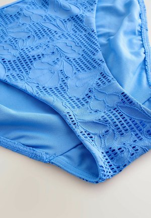 Ljust blå bikiniunderdel med en blommig spetsdesign, slät tygtextur och en blandad design med kontrasterande matt yta.