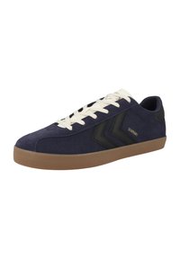 Navy suede sneakers with beige rubber sole, black accents, and white laces. Features a zigzag pattern on the side and logo detail.