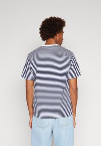 T-shirt rayé bleu marine et blanc avec un col rond et des manches courtes, en coton, présentant une coupe décontractée et un design classique.