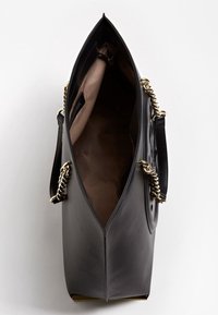 Zwarte handtas van kunstleer met een kettingaccent, open bovenzijde, gladde textuur en een contrasterende tankleurige binnenkant. Voorzien van een ritssluiting binnenin.