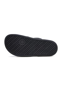 Suela de zapato de goma negra con ranuras horizontales y diagonales para tracción, forma redondeada y un acento circular cerca del centro.