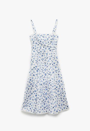 Vestido blanco sin mangas con estampado floral azul, corsé ajustado, dobladillo acampanado y encaje en el escote y el dobladillo.