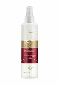 Klar sprayflaska med vit kropp och silverpump. Guld- och röd etikett med texten "K-Pak Color Therapy Luster Lock Multi-Perfector." 200 ml.