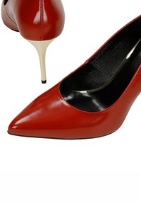Czerwone czółenka z lakierowanej skóry, z ostrym noskiem i wąskim beżowym obcasem typu szpilka. Charakteryzują się połyskującym wykończeniem i czarną wyściółką wewnętrzną.