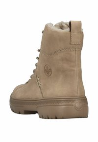 Bottes chelsea beiges en daim avec une finition texturée, dotées d'œillets métalliques, d'une doublure en fausse fourrure et d'une semelle en caoutchouc robuste.