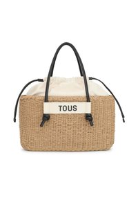 Bolso de paja trenzada con asas de cuero negro, parte superior con cordón crema y una banda blanca con el texto "TOUS". Diseño texturizado y rectangular.