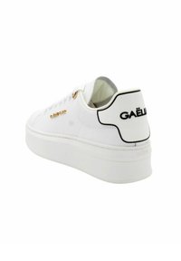 Sneakers in pelle bianca con una sola spessa bianca, dotati di accessori in oro e un accento con logo nero sul tallone. Texture liscia, design a punta rotonda.