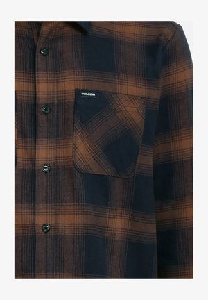 Chemise à carreaux bleu foncé et marron, avec un devant boutonné, deux poches poitrine et une étiquette de logo Volcom sur la poche gauche.