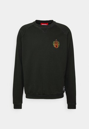 Schwarzes Sweatshirt mit Rundhalsausschnitt und langen Ärmeln, kleinem besticktem Wappen auf der linken Brust und einem rechteckigen schwarz-weißen Patch nahe dem Saum.