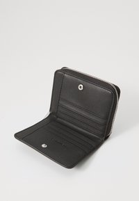 Fekete bőr pénztárca cipzárral, több kártyatartóval és patentos zárással. Simább textúra, minimalista dizájn.