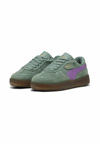 Baskets en nubuck vert clair avec une bande latérale violette, semelle en gomme, et lacets plats ; présente le logo PUMA sur la languette et le côté.