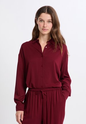 Camicia bordeaux a maniche lunghe con bottoni sul davanti, design con colletto, realizzata in tessuto morbido, abbinata a pantaloni con vita elastica per un fit rilassato.