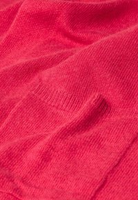 Tissu de pull en tricot de couleur rose vif, présentant une texture douce avec des détails côtelés subtils et des plis drapés. Aucun matériel ou accent visible.