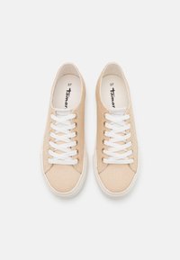 Sneakers in tela beige con suole in gomma bianca, lacci piatti e logo impresso all'interno. Taglia 37. Texture liscia con design a punta tonda.