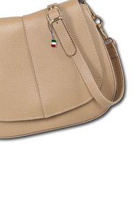 Beige leren handtas met een gestructureerde vorm, gouden hardware en een klein Italiaans vlaggetje als bedel. Inclusief verstelbare schouderriem.