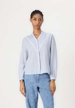 Blue and white striped button-up shirt with a collared neckline, pleated front, and long sleeves, paired with light blue textured pants.