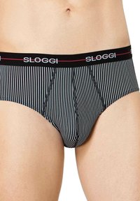 Czarno-białe paskowane majtki typu slip z elastycznym paskiem w talii, na którym widnieje logo "Sloggi" w kolorze srebrnym i czerwonym. Miękki, elastyczny materiał.