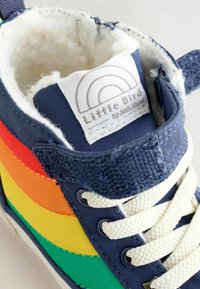 Tumes sinine kõrge ülikonna sneaker, millel on mitmevärvilised triibud (punane, oranž, kollane, roheline), tekstuuriga kangas, valged paelad ja pehme faux karvane vooder.