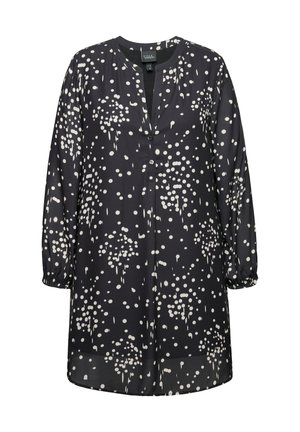 Černá tunika s bílým puntíkovým vzorem, výstřihem do v, dlouhými rukávy nařasenými na zápěstí a knoflíkovou légu na přední straně.