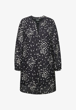 Túnica negra con estampado de lunares blancos, escote en V, mangas largas con puños fruncidos y una botonera en la parte delantera.