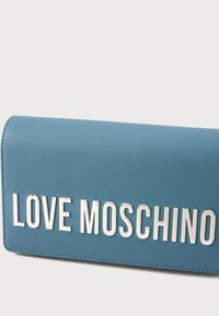 Portafoglio in ecopelle blu con la scritta metallica "LOVE MOSCHINO" ben in evidenza sulla parte frontale, texture liscia e bordi cuciti.