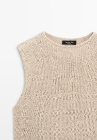 Beiger ärmelloser Strickpullover mit rundem Ausschnitt, mit einem schwarzen Label mit weißem Text „Massimo Dutti“ an der Innenseite des hinteren Kragens.