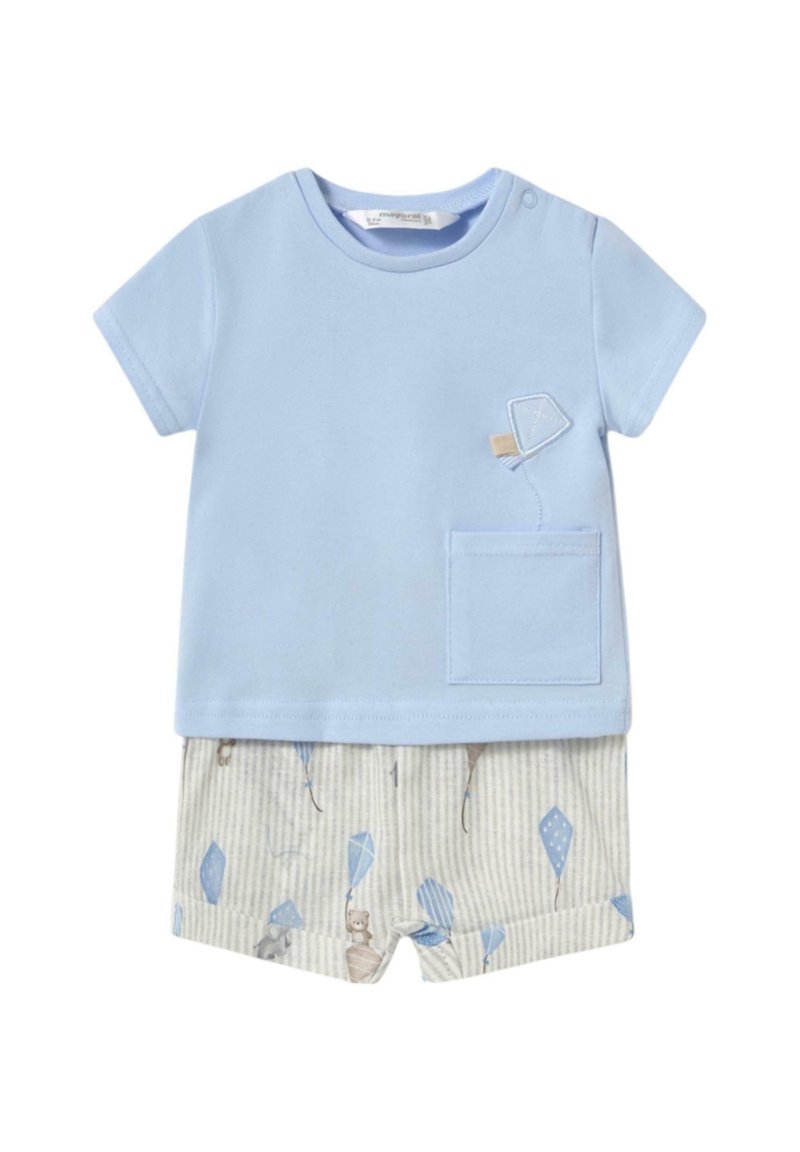 Camiseta de algodón azul claro con un bolsillo, combinada con pantalones cortos rayados beige claros que presentan un patrón divertido de cometas y animales adorables.