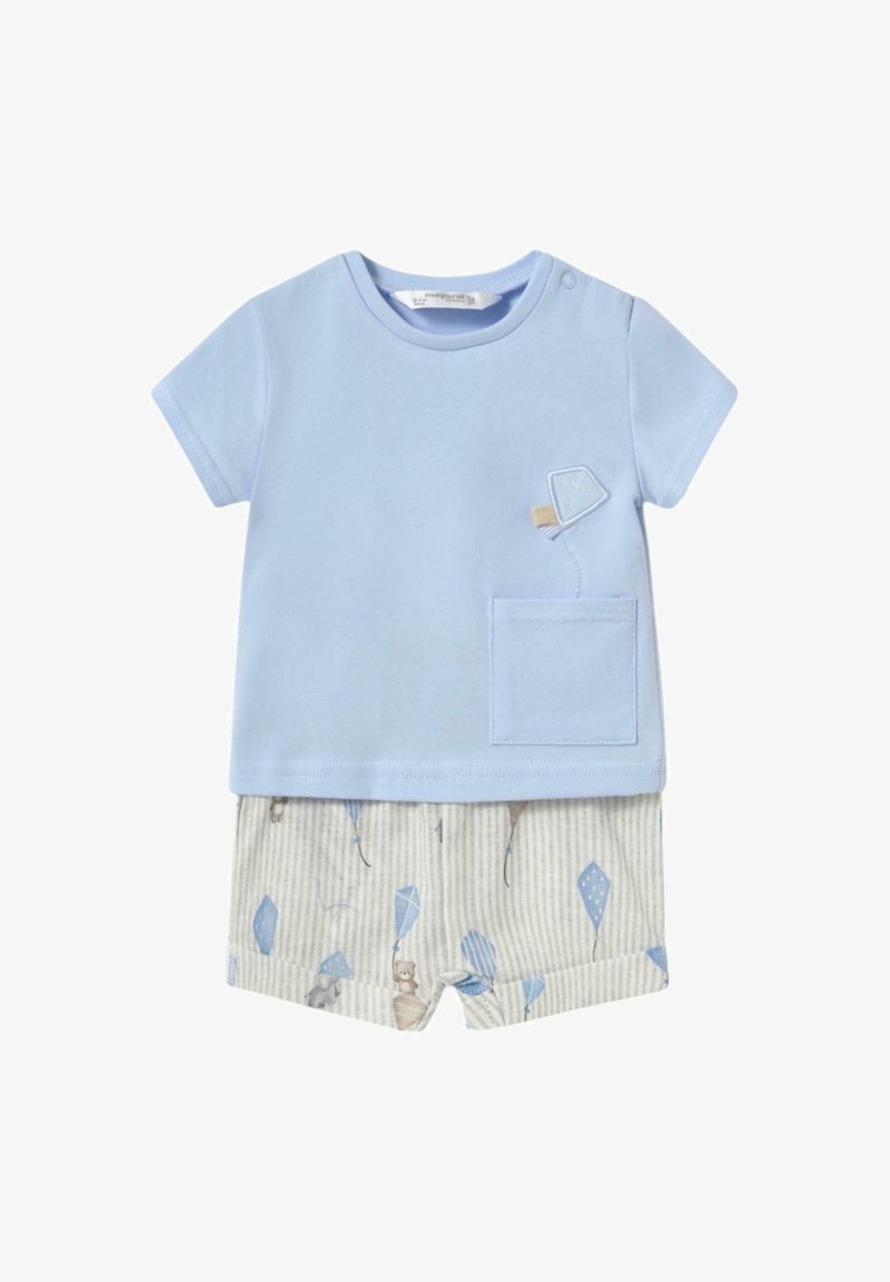 Camiseta de algodón azul claro con un bolsillo, combinada con pantalones cortos rayados beige claros que presentan un patrón divertido de cometas y animales adorables.