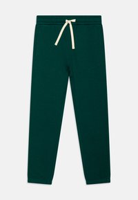 Dunkelgrüne Sweatpants aus einem weichen Baumwollmix, mit einem elastischen Bund und einer cremefarbenen Kordel, zwei seitlichen Taschen und schmal zulaufenden Beinen.