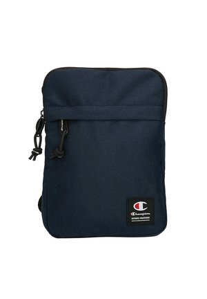 Piccola borsa a tracolla in tessuto blu navy con tasca frontale con cerniera e toppa con logo del marchio Champion vicino all'angolo in basso a destra.