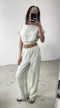Vihreä lyhythihainen crop-top, jossa on lyhyet hihat ja samankaltaiset löysät housut teksturoidusta kankaasta. Asusteina kuviollinen hiuspanta.