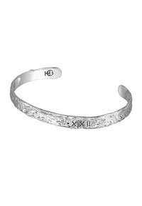 Silver cuff bracelet with a textured surface, featuring engraved patterns and subtle detailing, open-ended design for adjustable fit.