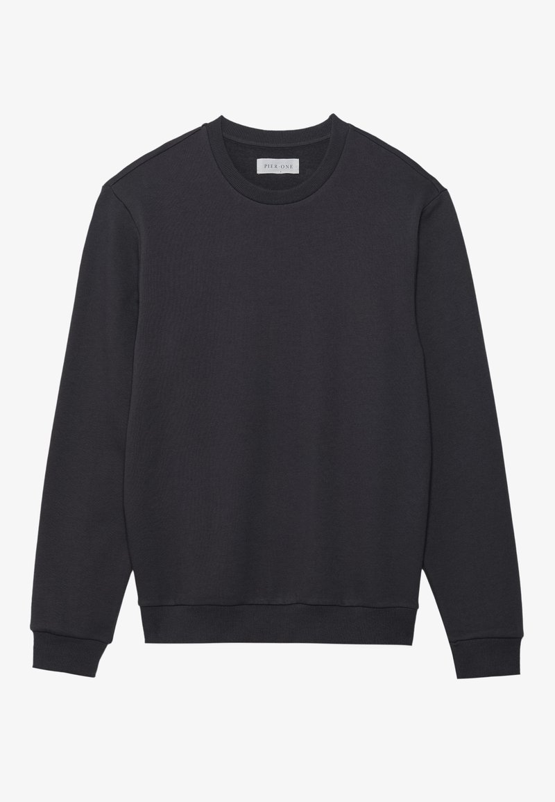 Sweatshirt noir à col rond en tissu doux et texturé avec des poignets et un ourlet côtelés. Présente un design minimaliste sans logos visibles.
