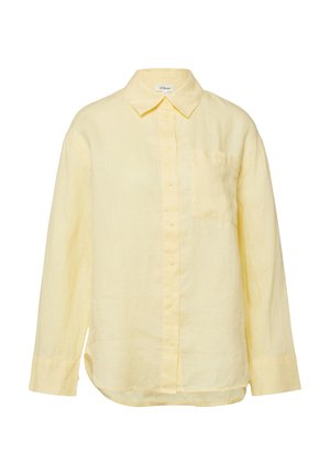 Chemise jaune pâle à manches longues avec col pointu et poche poitrine, fabriquée dans un tissu doux légèrement texturé.