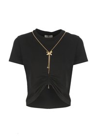 Camiseta corta negra de algodón con un frente fruncido y detalles en cadena dorada con un lazo y acentos colgantes.