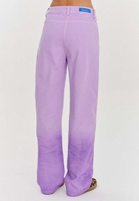 Levandulové kalhoty s širokými nohavicemi a hladkým povrchem, s vysokým pasem a jemným ombre efektem směrem k dolní části. Obsahuje modrou nálepku.