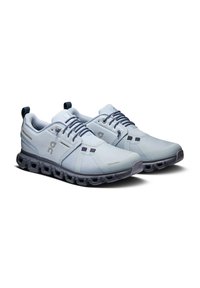 Light blue athletic shoes made of breathable mesh with a textured finish. Features a thick black sole with a unique cushioning design.