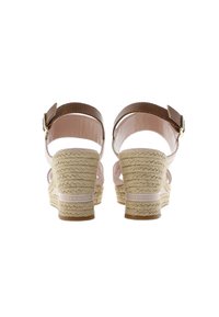 Hnědé sandály na klínu se stahovacími pásky, s pletenou jutu patou, růžovým vnitřním podšímáním a nastavitelným páskem kolem kotníku. Gumová podrážka pro lepší přilnavost.