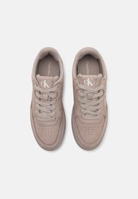 Beige semsket sneakers med rund tå, matchende snøring, perforerte detaljer på tåboksen og preget logo på tungen.